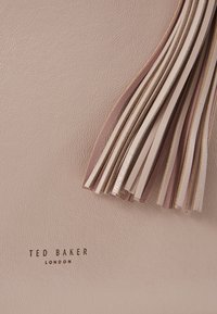 Różowa skórzana torba z frędzlami w różnych odcieniach i fakturach. Wytłoczone logo "Ted Baker London" w dolnej części.