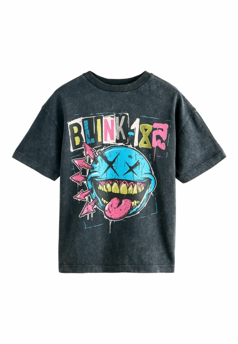 Camiseta de algodón negra con un estampado gráfico de una cara sonriente azul con dientes y una lengua saliente. El diseño incluye acentos coloridos y flechas.