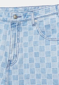 Jean en denim bleu clair avec motif quadrillé blanc, poche avant, passants de ceinture et fermeture par bouton argenté.