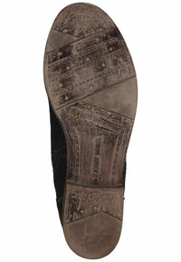 Sole di scarpe in suede nero con grip in gomma testurizzata, caratterizzata da un motivo a zigzag. Dettagli del marchio impressi vicino al tallone. Leggermente usate.