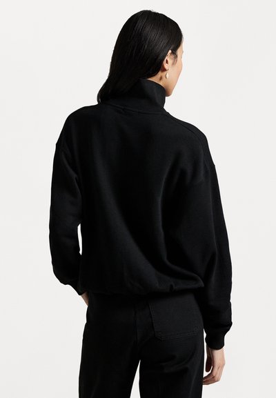 Schwarzer Pulli mit hohem Kragen, weichem Material und lockerer Passform. Verfügt über überschnittene Schultern und gerippte Bündchen für einen bequemen Look.
