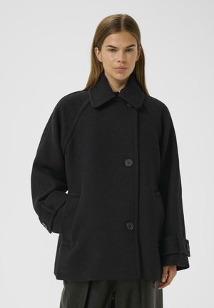 Black wool coat with a wide collar, button closure, and side pockets. Features a loose fit and raglan sleeves with buttoned cuffs.