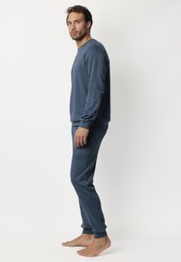 Conjunto de loungewear de algodón azul marino que incluye una camiseta de manga larga y pantalones con cintura elástica, textura suave con puños acanalados.