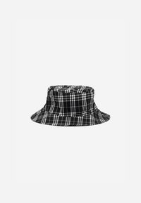 Chapéu bucket em preto e branco com aba larga, coroa estruturada e textura de tecido suave. Apresenta linhas verticais e horizontais no padrão.
