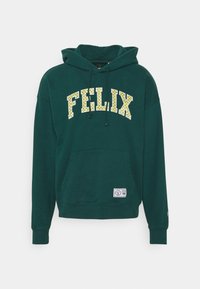 Felpa verde in cotone con tasca a marsupio frontale, cappuccio con coulisse e testo "FELIX" in giallo su uno sfondo decorato.