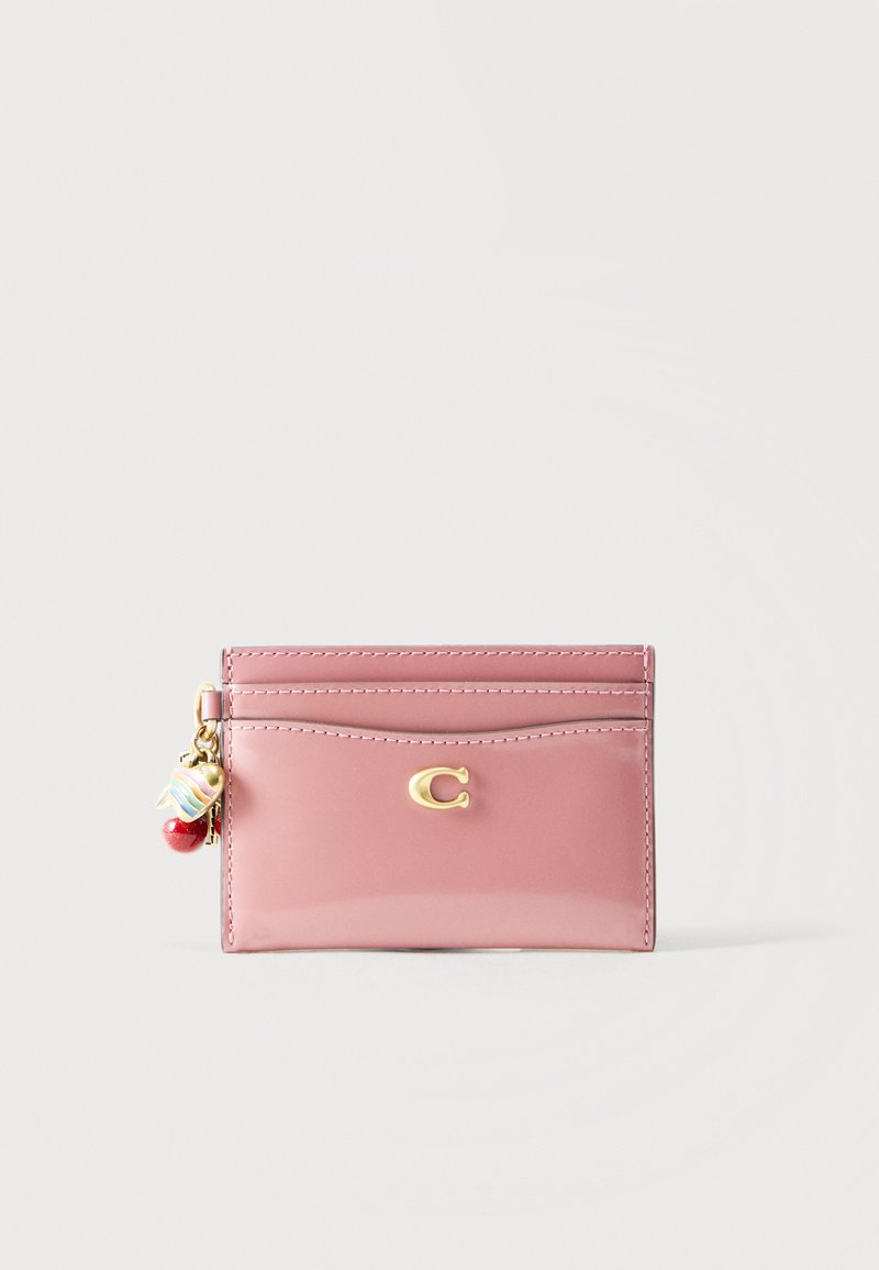 Ροζ δερμάτινη θήκη καρτών με χρυσό λογότυπο "C", πολλαπλές θήκες για κάρτες και διακοσμητικά καρδιάς και χάντρα προσαρτημένα στο φερμουάρ.