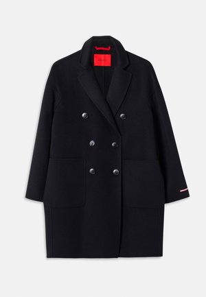 Black double-breasted coat with large front pockets, button detailing, and a soft texture. Features a contrasting pink accent on sleeves.