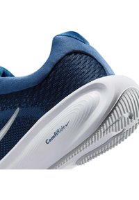 Modra tekaška čevlja Nike z belim ComfiRide penastim podplatom in teksturiranim oprijemom na podplatu.