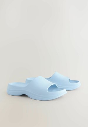 Világoskék gumiszandálok nyitott orral, lekerekített formával és sima textúrával, alacsony, vastag talppal.