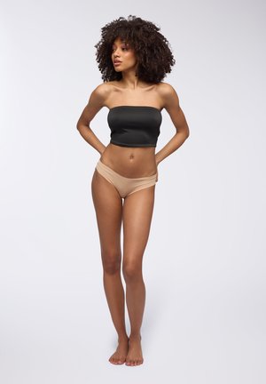 Czarny top bandeau i cieliste majtki boyshort, materiał wydaje się elastyczny, gładka tekstura, dopasowany krój, model z rękami na biodrach.