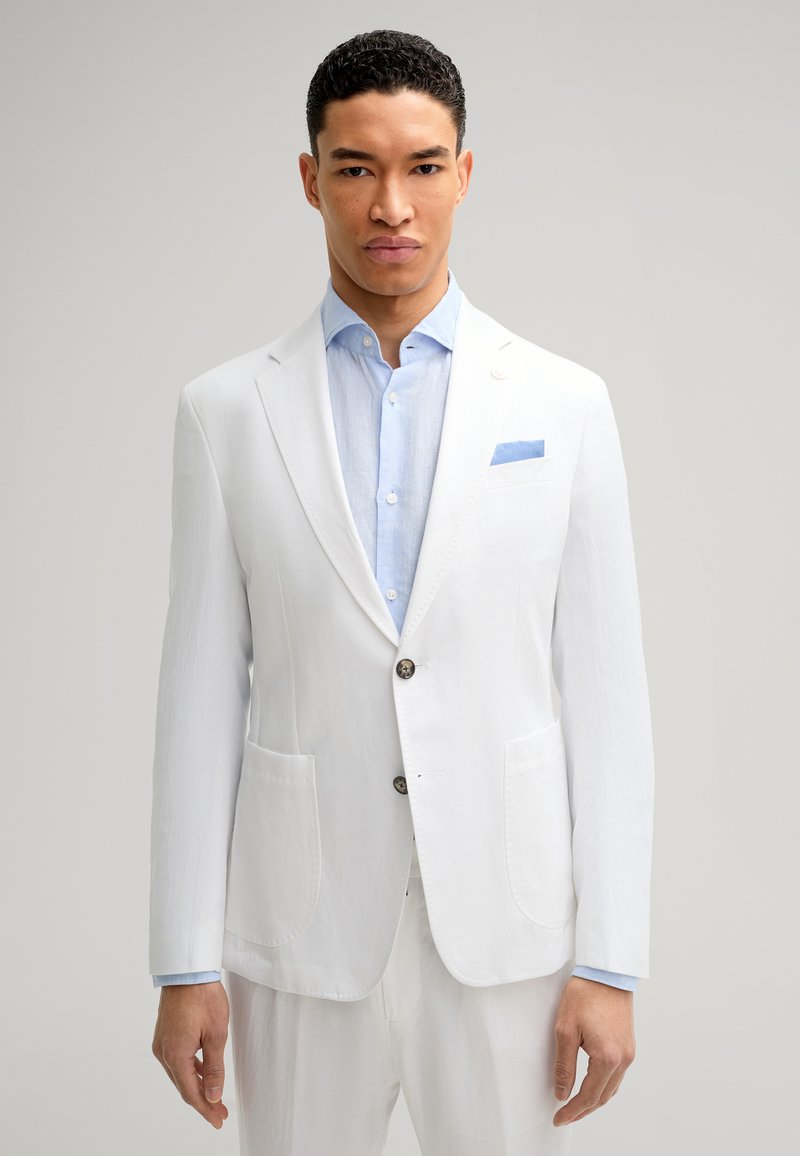 Weißer Leinenblazer mit zwei vorderen Taschen, Ein-Knopf-Verschluss, kombiniert mit einem hellblauen Hemd und einem blauen Taschentuch.