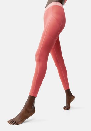 Leggings rosa con una texture liscia e elastica, caratterizzati da cuciture a contrasto e un cintura alta. Le gambe sono aderenti e si restringono alla caviglia.