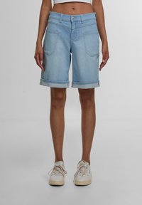 Shorts en denim bleu clair avec un ourlet retroussé, un design à cinq poches et une fermeture à bouton. Texture lisse, longueur raccourcie et style classique.