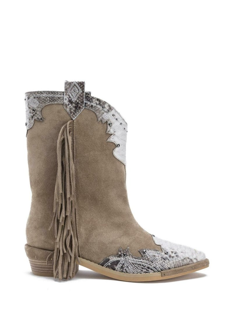 Boty ve westernovém stylu z béžového semiše s dekorativním stříbrným krytem na špičce a třásněmi vzadu. Obsahují kovové doplňky a prošívání.