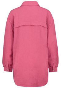 Langärmliges Hemd in leuchtendem Pink, strukturierter Stoff mit Kragen, geknöpften Manschetten und Rückenteil mit Passe. Saum ist abgerundet und leicht verlängert.