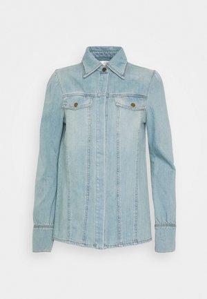 Veste en denim bleu clair à manches longues, col, poignets boutonnés et deux poches poitrine avec boutons métalliques.