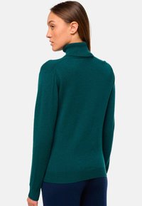 Türkiser Rollkragenpullover aus weichem Strickmaterial, mit enganliegender Form, geripptem Kragen und langen Ärmeln, mit glatter Textur.