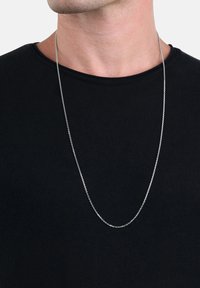 Collar de cadena de plata, enlaces redondos, superficie lisa, diseño en capas, usado sobre una camiseta negra de cuello redondo. Estilo simple y minimalista.