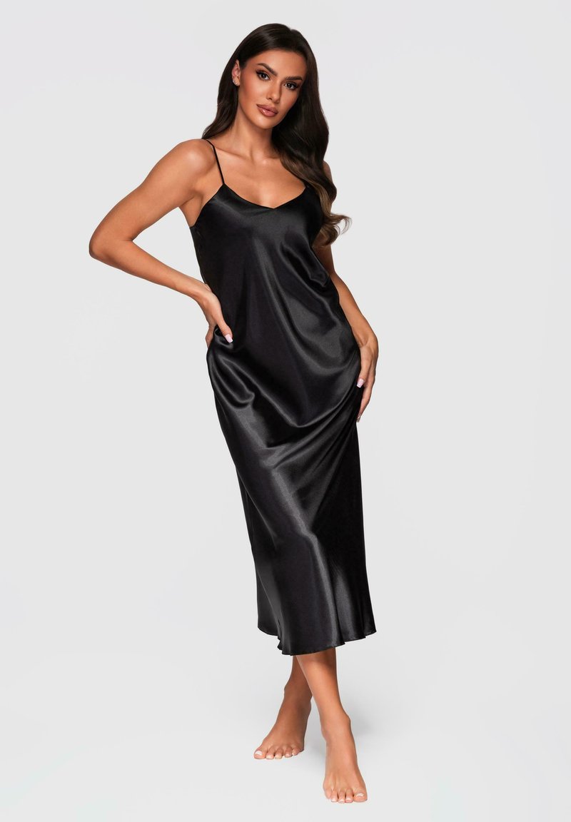Vestido de satén negro, tipo slip, con tirantes finos, de longitud a la rodilla, textura suave y sutil brillo, que presenta un corte holgado y un escote en V profundo.