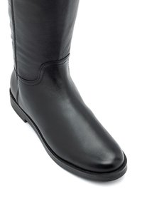 Czarne skórzane, wysokie do kolan botki o gładkiej fakturze, zaokrąglonym nosku i minimalnych detalach stębnowania. Posiadają niską gumową podeszwę dla stabilności.