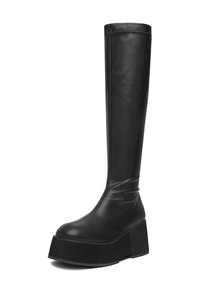 Botín negro por encima de la rodilla hecho de cuero suave, con una suela de plataforma gruesa y una puntera redondeada. Diseño elegante con costuras mínimas.