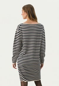 Abito a righe nei colori blu marina e crema, con maniche lunghe, scollatura a barca e una vestibilità leggermente ampia, che arriva a metà coscia.