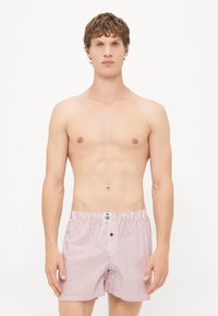 Rot-weiße gestreifte Boxershorts mit einem elastischen Bund und einem Knopfdetail. Glattes Baumwollmaterial mit einem lässigen Schnitt.