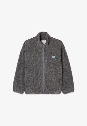 Temno siva flis jakna z zadrgo po celotni dolžini, teksturirano tkanino, stoječ ovratnik, elastične manšetne in mali modro-zeleni znak na levi strani prsnega koša.