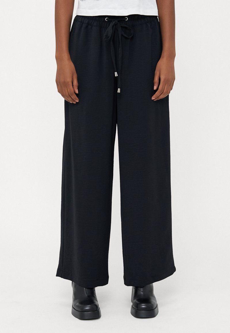 Pantaloni neri a gamba larga con vita regolabile e accenti in metallo argentato, realizzati in un morbido e leggero tessuto. Design classico e spazioso.
