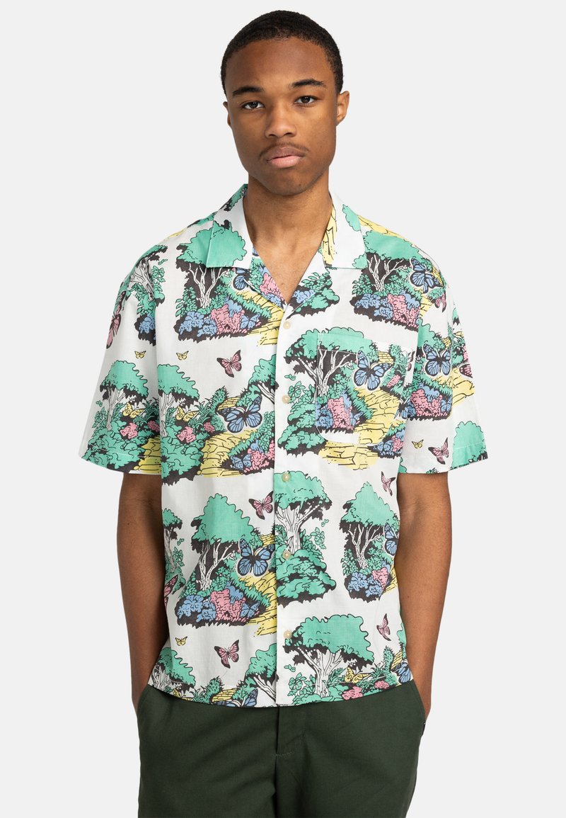 Chemise à manches courtes avec un fond blanc et des motifs botaniques et de papillons colorés dans des nuances de vert, rose et bleu.