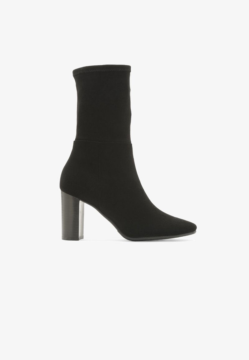 Bottine noire mi-mollet avec bout pointu et talon bloc, tige en tissu lisse avec détail de couture latérale sur fond blanc.
