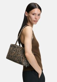 Torba na ramię z motywem lamparciego cętka wykonana z tkaniny, o usztywnionym, prostokątnym kształcie, z krótkimi uchwytami i akcentami w odcieniu srebra.