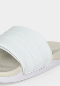 Sandale blanche à enfiler avec large bride texturée et semelle intérieure rembourrée, conçue pour un usage décontracté.