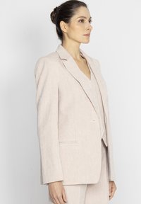 Jasnoróżowa marynarka z mieszanki lnu, z wywijanymi klapami, zapięciem na jeden guzik oraz bocznymi kieszeniami. Gładka tekstura, klasyczny fason dopasowany.