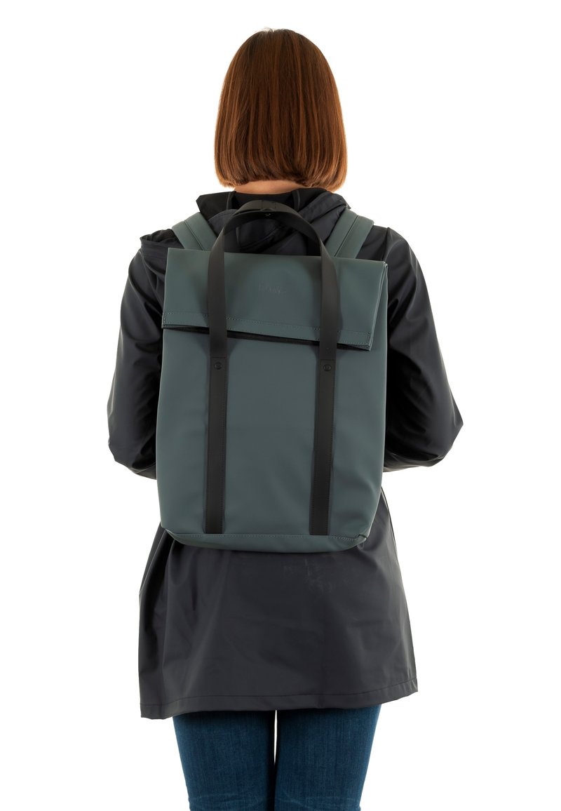 Mochila rectangular verde con correas negras, hecha de material texturizado, que presenta un cierre de solapa y un diseño minimalista.