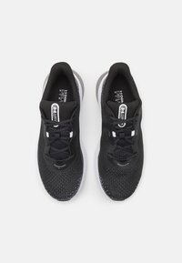 Schwarze Sportschuhe mit einem atmungsaktiven Mesh-Obermaterial, weißen Akzenten, abgerundeter Spitze und Schnürsenkeln. Dämpfende Zwischensohle mit strukturiertem Außensohlen-Detail.
