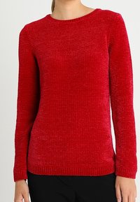 Červený pletený svetr s kulatým výstřihem, dlouhými rukávy, texturovanou tkaninou, žebrovaným lemem a úzkým střihem.
