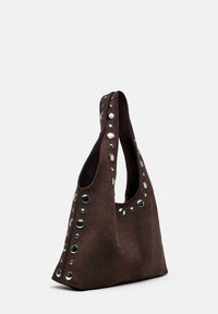 Borsa a mano in suede marrone scuro con una maniglia larga, decorata con grandi e piccoli rivetti argentati lucidi lungo i bordi.