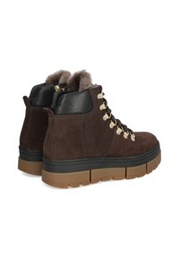 Braune Wildleder-Stiefeletten mit schwarzen Lederakzenten, goldenen Ösen und einer dicken, strukturierten Gummisohle mit geriffeltem Design.