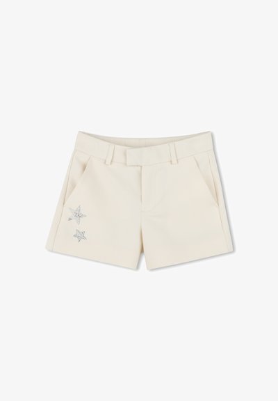 Shorts crème avec une texture lisse, présentant deux poches avant et des accents de étoiles en rhinestones décoratifs sur la poche gauche.