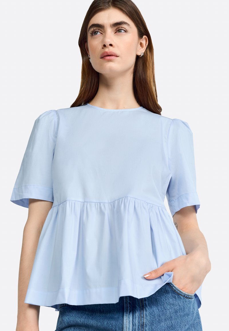 Lichtblauw blouse met korte mouwen en een ronde hals, voorzien van een gezameld peplumontwerp en een gladde, lichte stof.