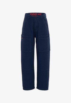 Pantalon cargo bleu marine avec poches à rabat à l'avant, passants pour ceinture, fermeture à boutons, et marquage rouge "HUGO | 446" à l'intérieur de la ceinture.