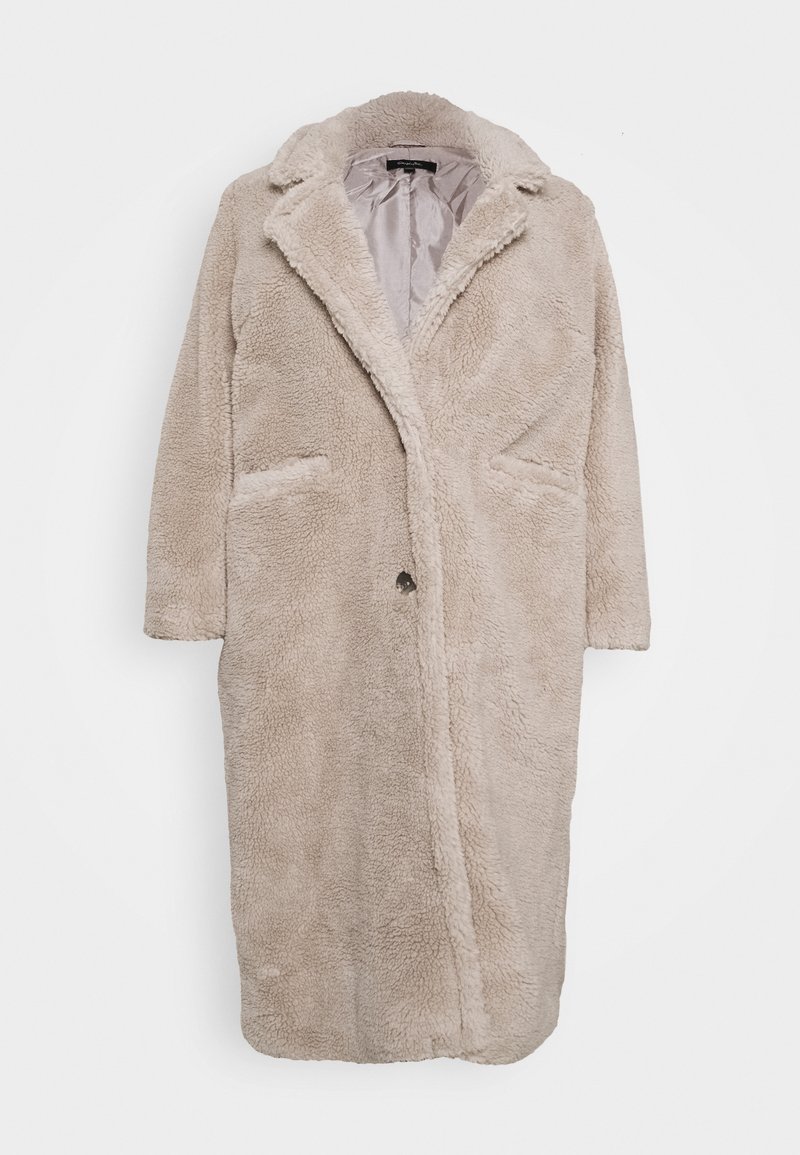 Long manteau beige en fausse laine bouclée avec col à revers, fermeture avant à boutons et deux poches latérales, présenté sur un fond blanc uni.
