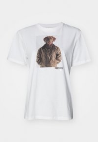Bílý bavlněný tričko s grafikou psa v hnědém saku. Text "BARBOUR" vytištěný černě vpravo dole. Volný střih.