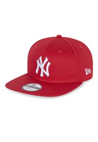 Gorra snapback roja de tela, con logo bordado en blanco, visera plana y ojales de ventilación en la parte superior. Correa ajustable en la parte posterior.
