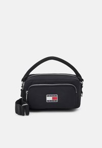 Czarna nylonowa torba na ramię z teksturowaną powierzchnią, podwójnymi zamkami błyskawicznymi i naszywką z logiem z przodu; posiada uchwyt górny oraz regulowany pasek.