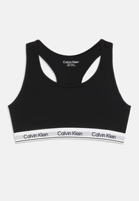 Czarny stanik sportowy Calvin Klein dla dzieci w wieku 10-12 lat z plecakiem i białą elastyczną taśmą z powtarzającym się logo Calvin Klein.