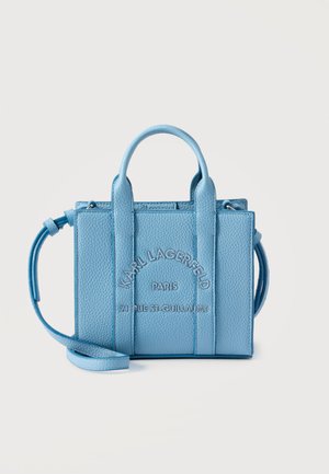 Sac à main en cuir bleu clair texturé avec deux poignées courtes, une sangle longue, et « Karl Lagerfeld Paris 21 Rue St-Guillaume » embossé sur le devant.