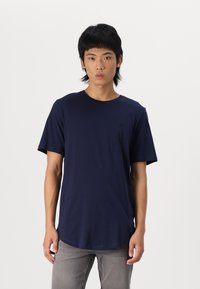 Marineblaues T-Shirt mit kurzen Ärmeln aus Baumwolle, mit Rundhals und einem dezenten Logo-Detail auf der Brust. Weicher Stoff, lässige Passform.