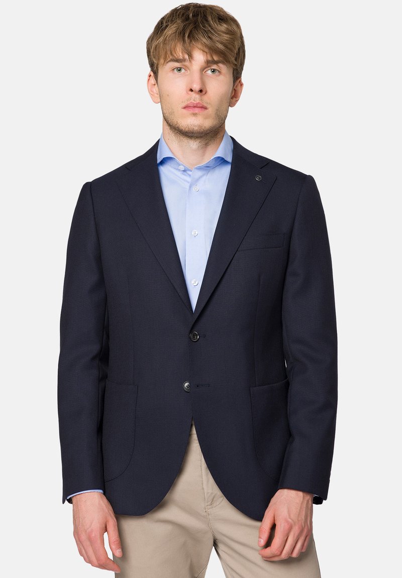 Granatowa marynarka wykonana z teksturowanej tkaniny, z dwiema kieszeniami z przodu, dwoma guzikami oraz dopasowanym krojem. Wnętrze ma gładkie wykończenie.